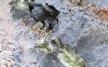 Blue and white clay zones in an Oregon deposit, separated by a vein of rock containing sulfur.